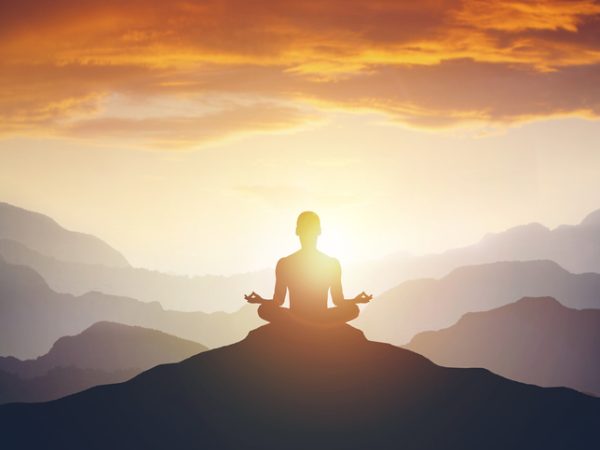 Silhouette of the meditaion man on the mountain. Leadership Concept